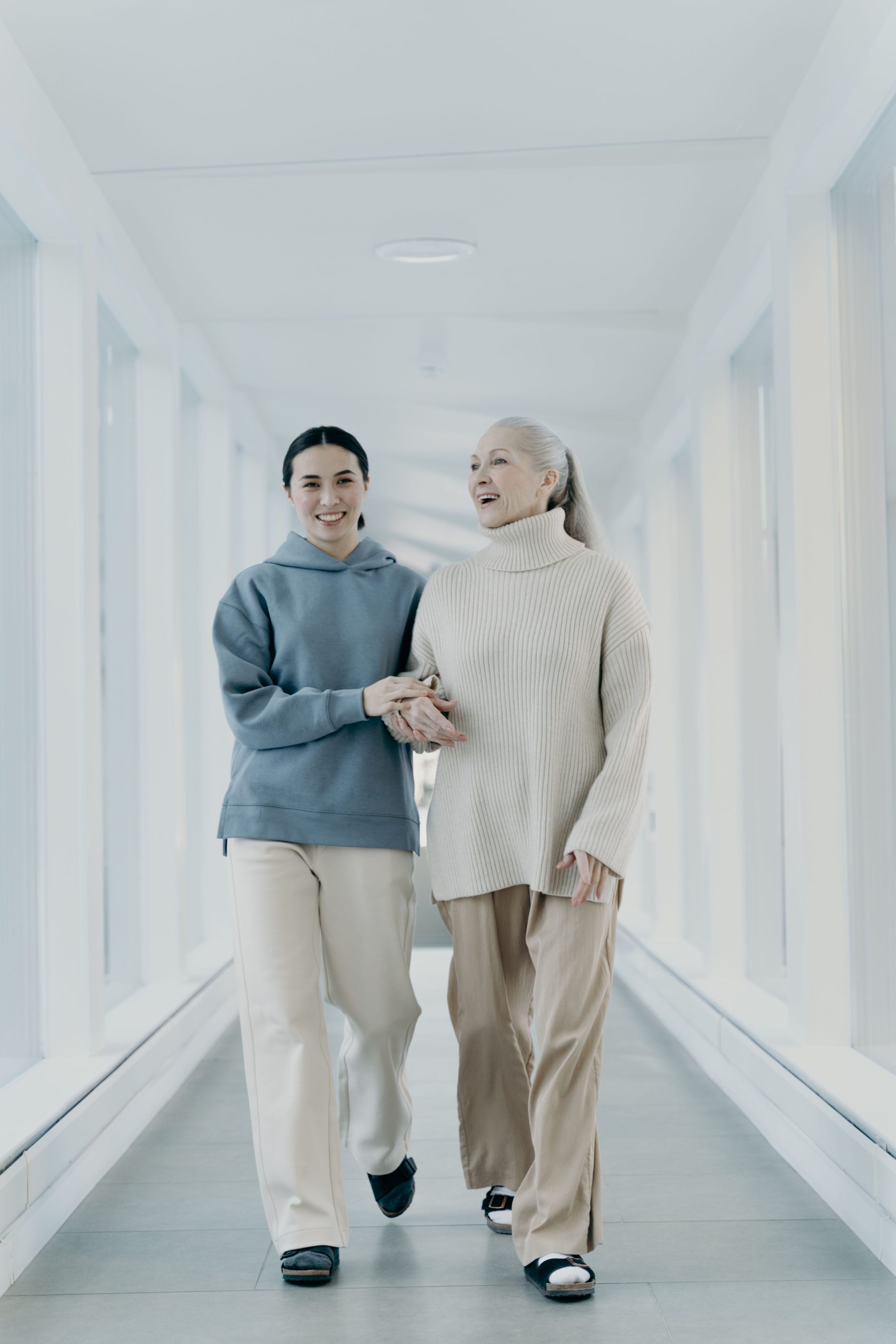 A carer and client walking together arm in arm